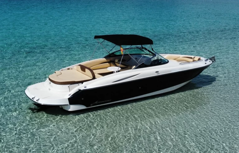 Monterey 278 Super Sport with a black hull and sun canopy on clear turquoise water