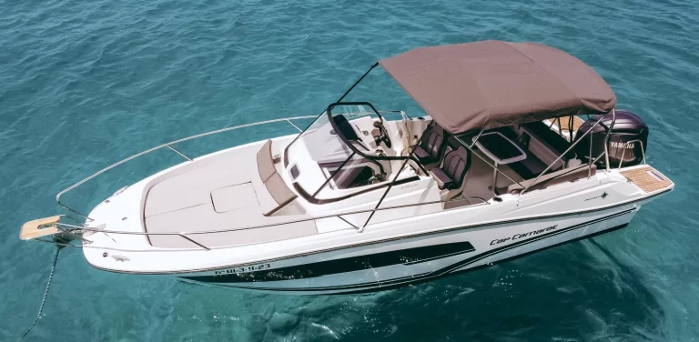 Jeanneau Cap Camarat 7.5 WA S3 with a bow solarium and sun canopy anchored in Ibiza