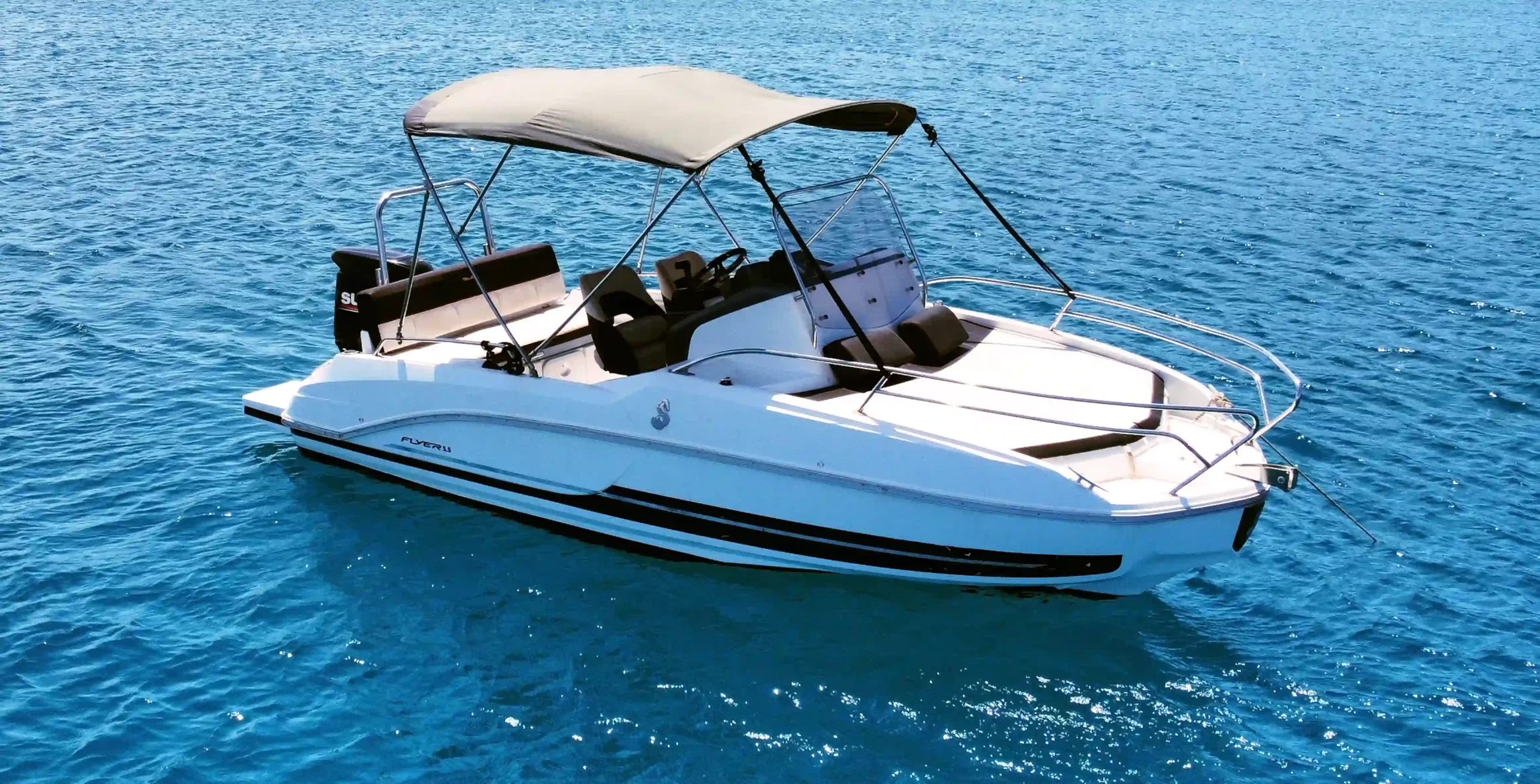 Beneteau Flyer 5.5 Sundeck with a bow solarium and sun canopy anchored in blue water