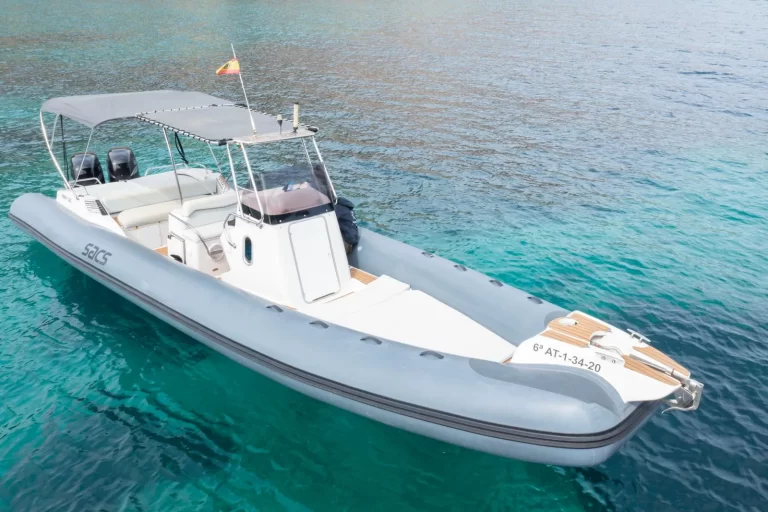 Sacs 33 RIB with a bow solarium, sun canopy and twin outboard engines in turquoise waters off Ibiza